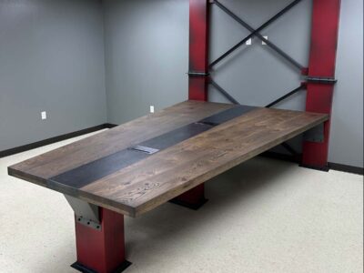 industrial conference table - solid wooden table top with inlaid flat black steel center piece, Flat black and distressed red base and wall feature.