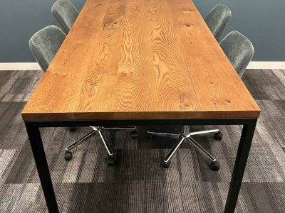 LIGHT STAINED OAK OFFICE MEETING TABLE WITH BLACK SLEEK LEGS AND PLUSH GREEN ROLLING CHAIRS